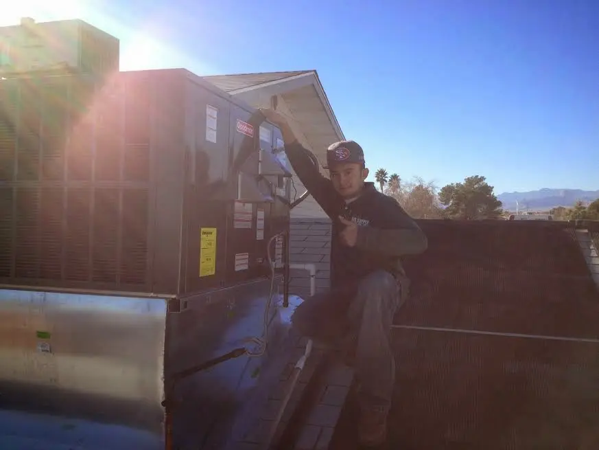 HVAC technician performing Air Duct Cleaning on a rooftop unit in Leeds
